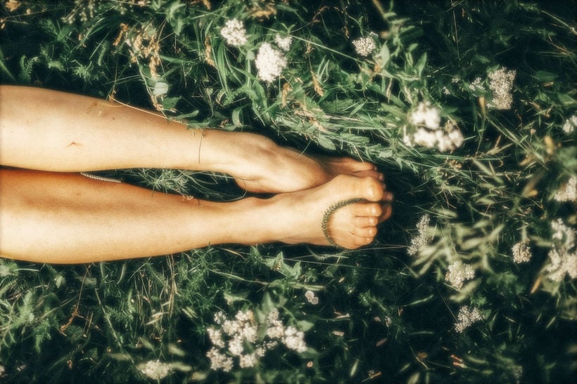 Woman's legs and feet lying on soft grass